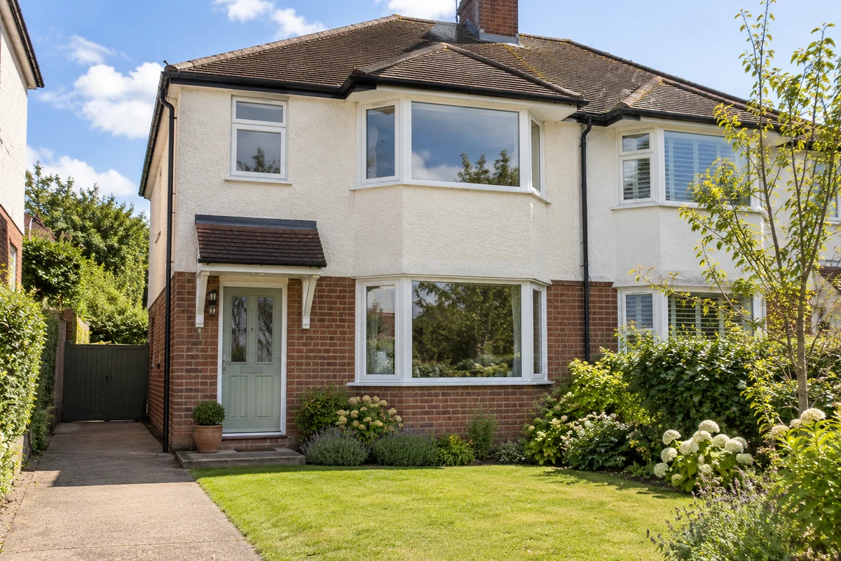 Interwar semi-detached house with white bay windows up and down