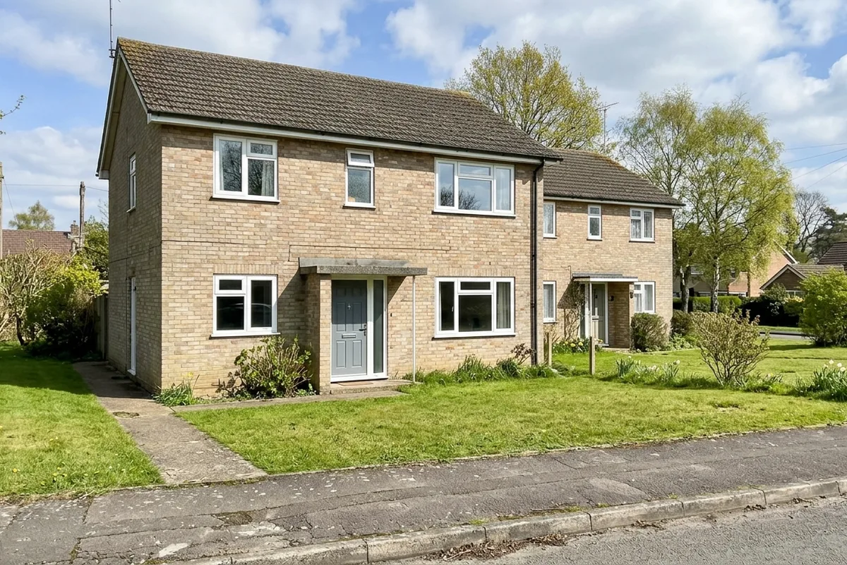 Post-war semi-detached house with white casement windows in sunshine